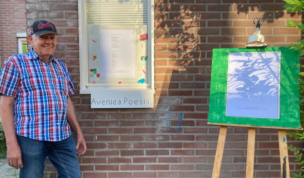 Dorpsdichter Nico Croes bij een raamgedicht aan de Goudvinkhaag in juli dit jaar