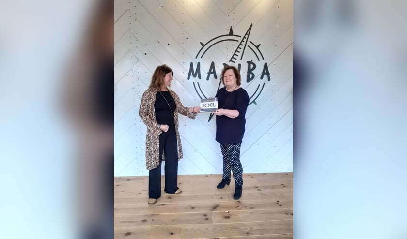 Mary Claassens van Projecthuis Madiba (links) ontvangt een schoolplanner uit handen van uitgeefster Ilse van der Stoep (rechts).