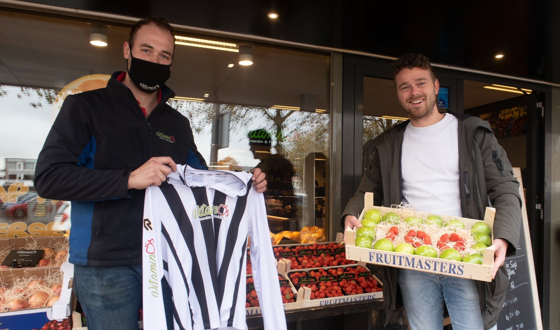 Groenteboer en sponsor Guido van Os (links) overhandigde zaalvoetballer Niels Meerkerk een fruitkistje ter ere van zijn honderdste doelpunt.