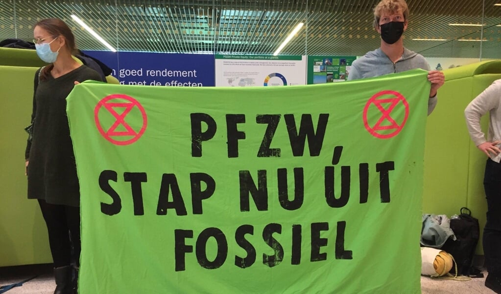 Zorgmedewerkers houden spandoeken vast met de tekst ‘PFZW stap nu uit fossiel'.