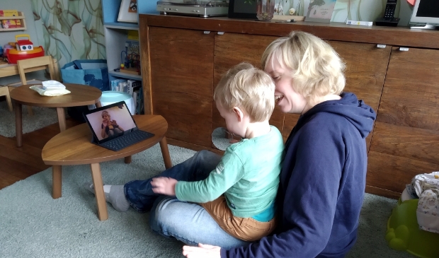 ouder en kind volgen een online muziekles