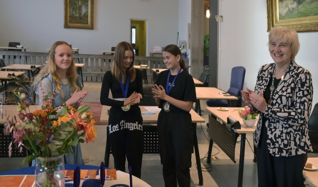 Ciara van de Sluis en Alena Davidse ontvingen uit handen van kinderburgemeester Aline een jongerenlintje voor een gezamelijke goede daad.