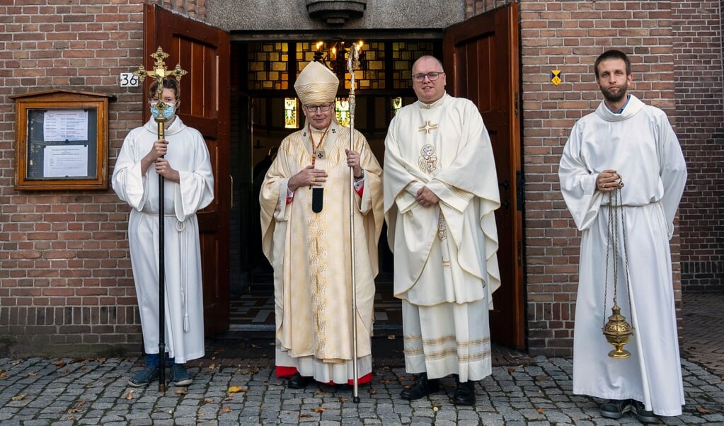 Kardinaal Willem Eijk (midden links) en pastoor Harrold Zemann met twee misdienaren. Ze gingen zondag voor in de eucharistieviering in de St. Catharinakerk.