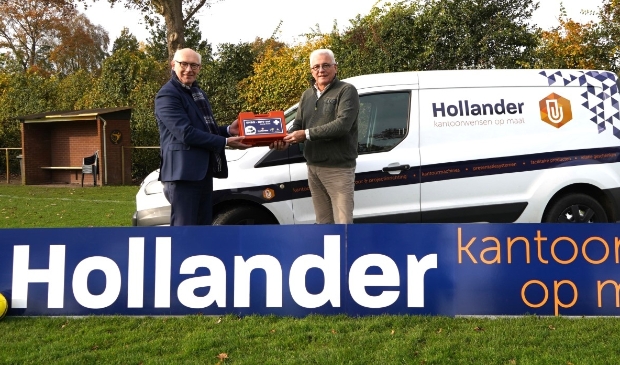 <p>Harry Hollander (r) overhandigt Lammert Vlieger een EHBO-BHV-kit, waarvan alle teams een exemplaar hebben ontvangen en tevens zijn nieuwe reclamebord op sportpark De Heughte</p>