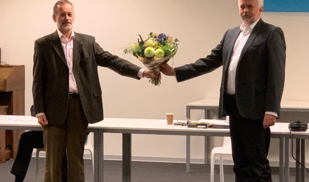 Partijvoorzitter Kees Pille bekroont de benoeming van Willem Pors (rechts) met bloemen.