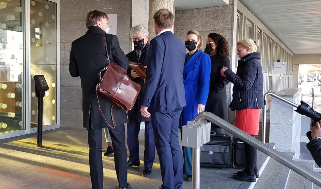 Commissaris John Berends en zijn kabinetschef Katinka Oldenburger (4e van links) samen met de advocaten van Stibbe bij de entree van de rechtbank