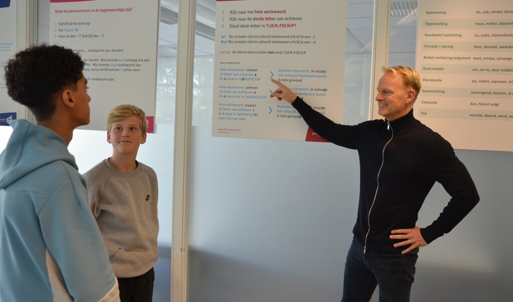 Docent Niels Jongkind geeft Adam (l) en Rafael uitleg met behulp van de nieuwe schoolplaten.