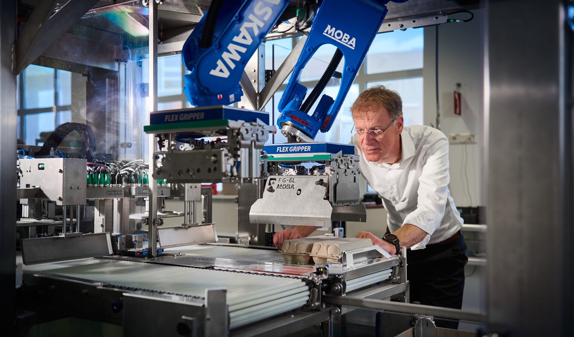 Directeur Edwin Bolwerk bij één van de eierinpak-robots van Moba.