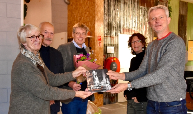 Peter Beijer overhandigt het eerste boek aan Loes Jak. Man Bert Revier (links), mede-auteur Lex Bergers en vormgeefster Erica Heykoop zijn ook van de partij. 