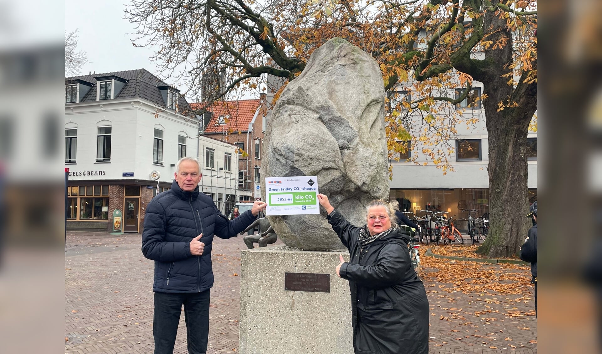 Mieke Bleij, directeur Kringloopcentrum Amersfoort–Leusden en Frans Schrijver, directeur Acht+ Meerwarenhuis bieden CO2-cheque aan gemeente Amersfoort aan.