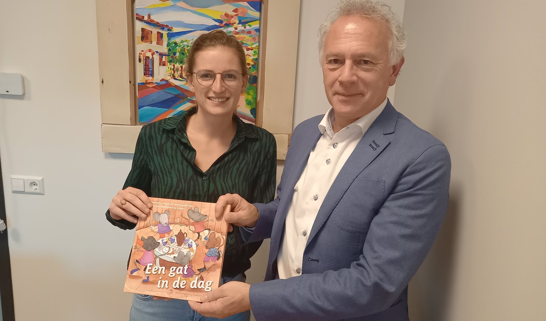 Leerkracht Mirjam de Vos en haar vader Willem, rector van het CLV, met hun gezamenlijke productie gebundeld in 'Een gat in de dag'. 