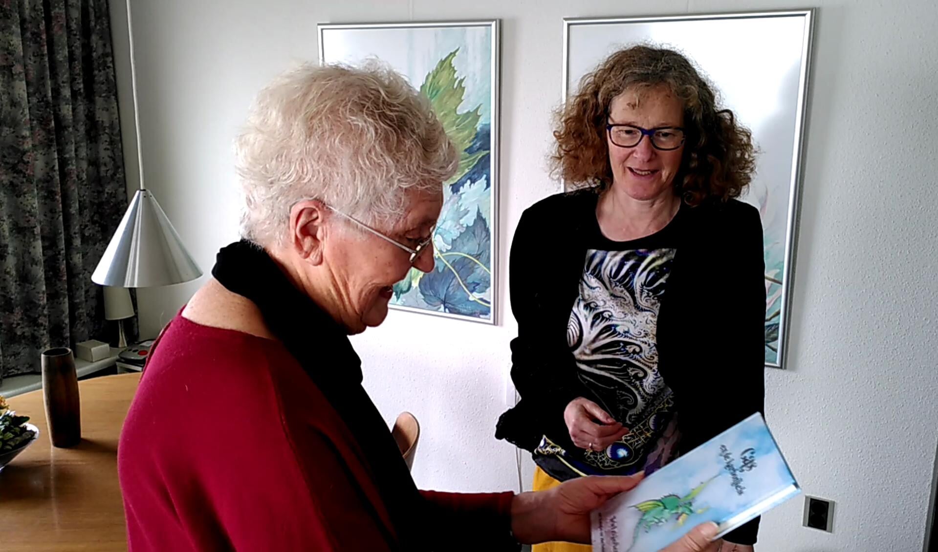 Overhandiging boek aan de illustratrice Joke Nederhand-Wijnbergen door de schrijfster Iris Lekkerkerk (rechts) 