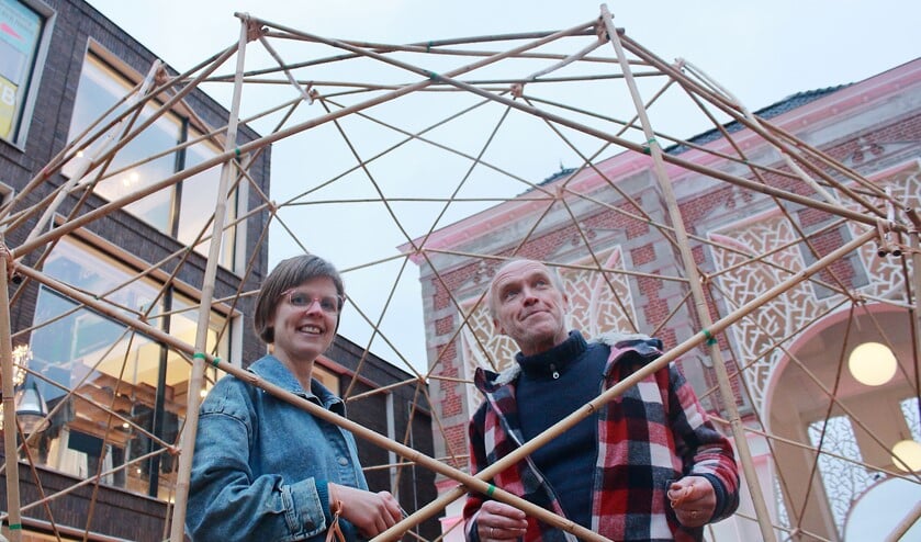 Narda Beunders en Stef Bos in de bamboe-structuur van hun zelf gebouwde gemeenschapsruimte.