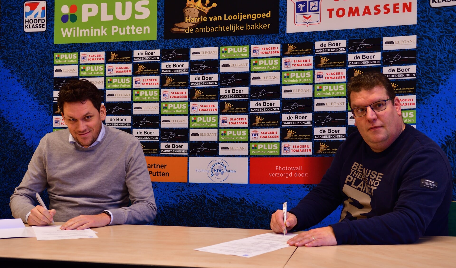 Hoofdtrainer Mark Bakker (links) en voorzitter Dimri Bruggeman ondertekenen het nieuwe contract.
