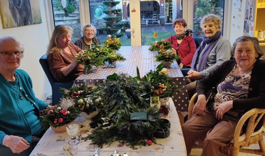 Kerststukjes maken bij zonnebloemvrijwilliger thuis.