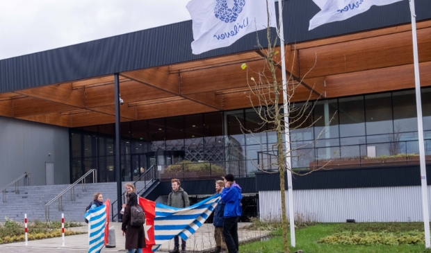 Studenten staan met de Morgenster vlag voor het gebouw van Unilever