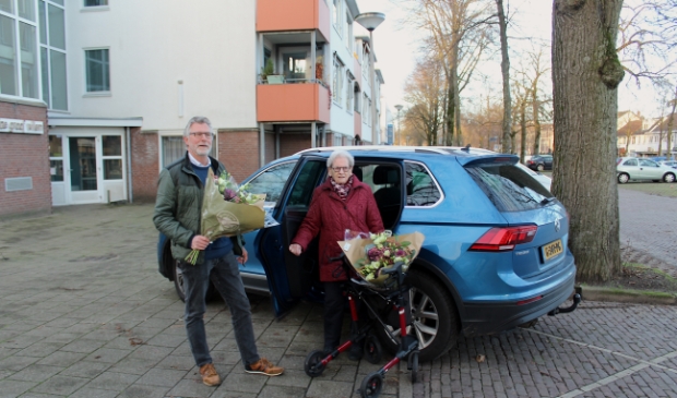 Chauffeur Fons Reijers en deelneemster Lutske de Raaf in de bloemen bij de 1000ste rit van AutoMaatje