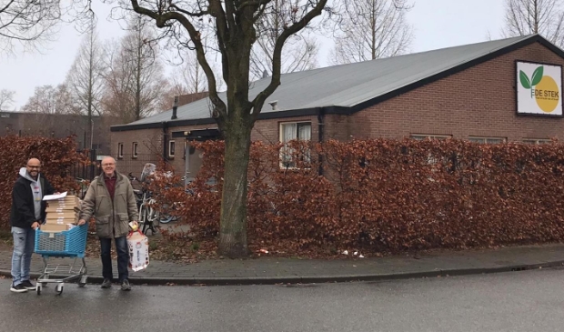 Vrijwilligers delen brieenburs-kerstpakketjes uit in De Bloemenbuurt in Ede