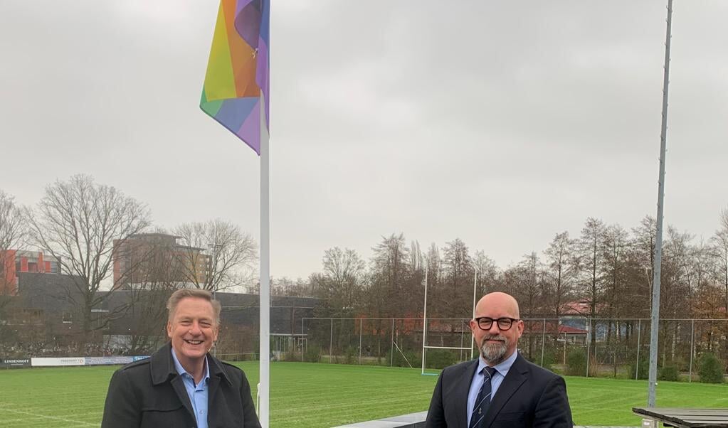 Wethouder Rob Ellermeijer (Sport) en Robert Fennis van ARC bij een regenboogvlag. hét symbool voor de lhbti+-gemeenschap. 