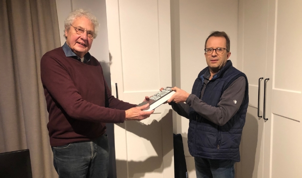 David Mather (r) overhandigt het boek aan Arnold v.d. Kamp (l)