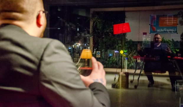 Tim Horsting draagt voor door de telefoon vanuit de bblthk
