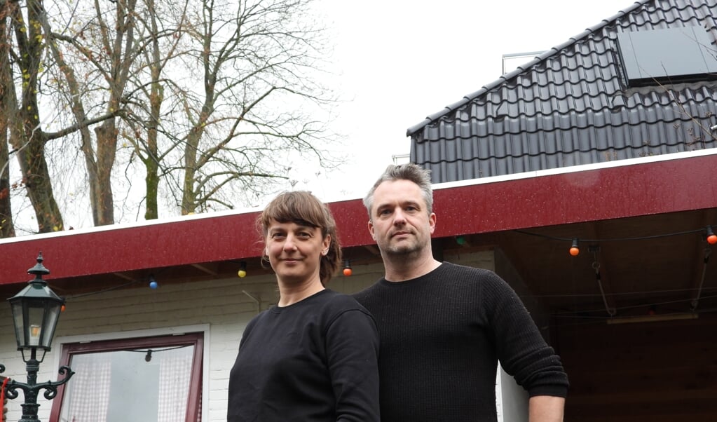  Annemieke Dunnink en Arjen Pas in hun achtertuin met zicht op een twee-onder-een-kap woning en de nog niet gekapte bomen aan de Hazelaarhof.  