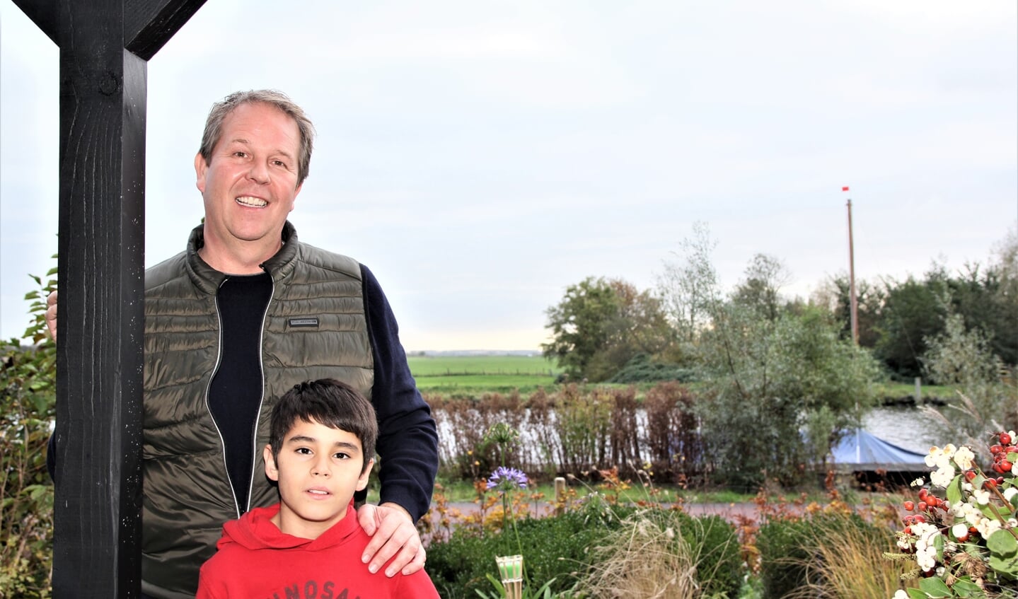 Remy Rodenhuis en zijn zoon Lloyd. Aan de overzijde van de Ringvaart het groene Kaageiland.