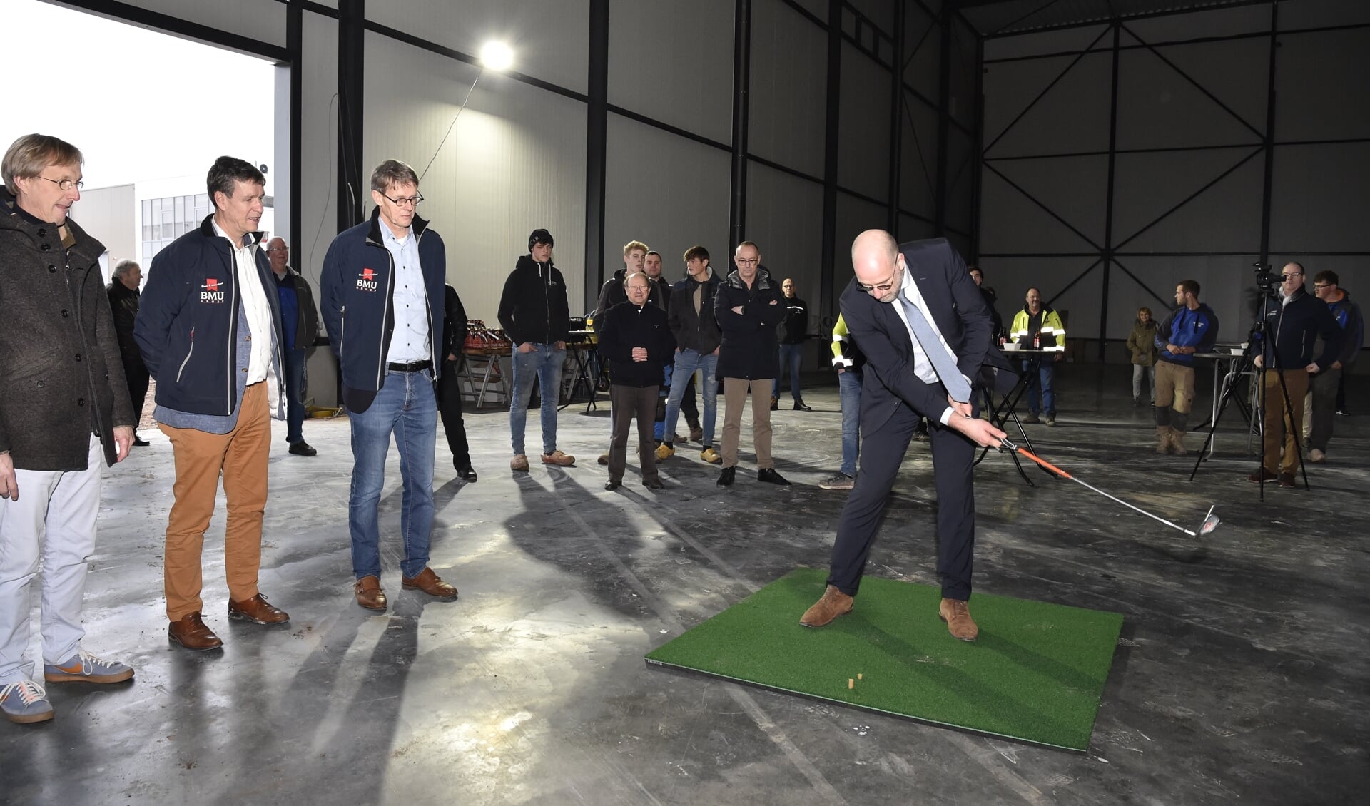 Wethouder Harrie Dijkhuizen sloeg de eerste golfbal in de magazijnhal van Duchell dat zich richt op de inrichting van onder meer golfbanen.
