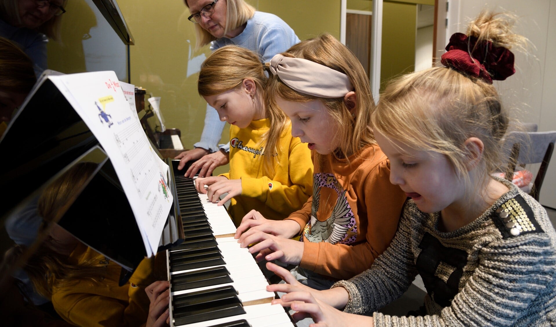 Drie kinderen uit één gezin gaan pianoles volgen