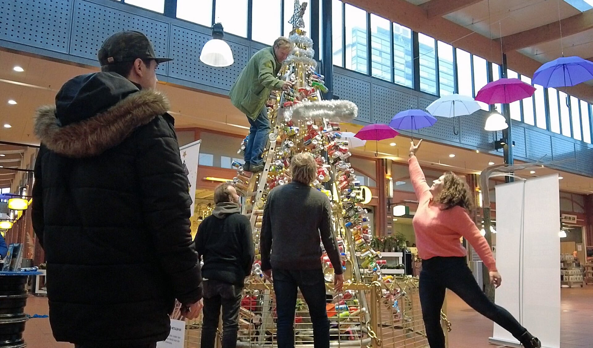 Kerstboom van gerecycled materiaal - de slingers worden toegeworpen