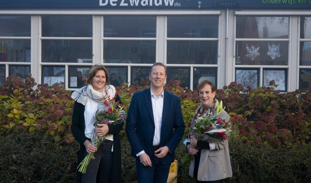 Ingrid Poelstra (rechts) en haar opvolgster Karine Emons kregen bloemen van wethouder Frank Berkhout (Onderwijs).