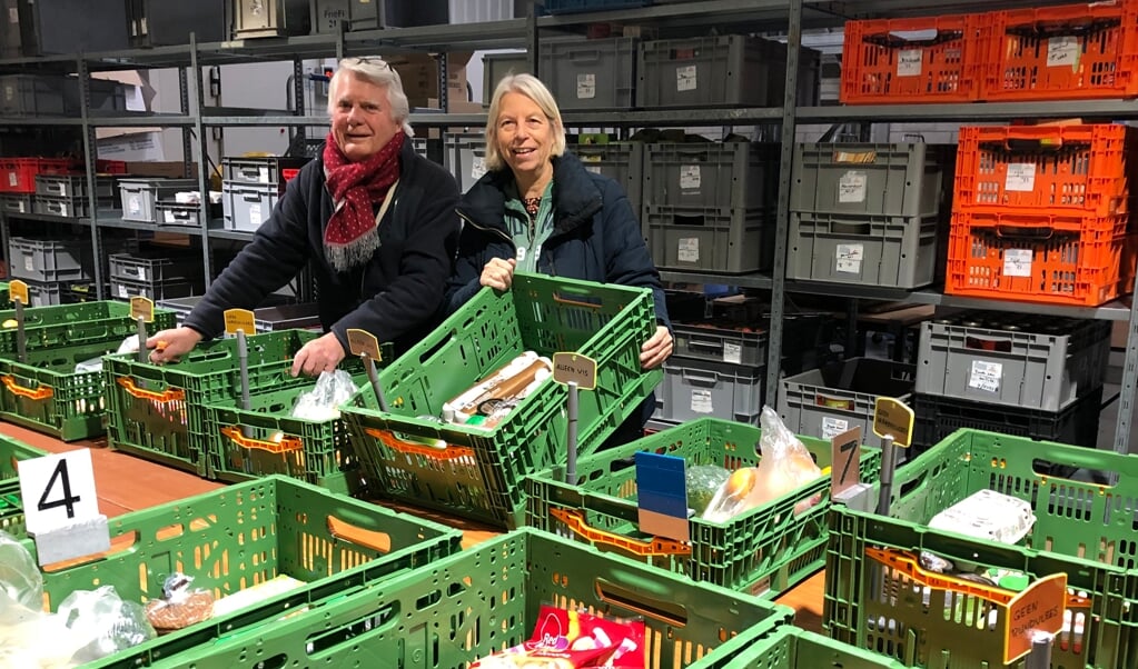 Reinier van Kuyk en Claudette van Soomeren, coördinator van de voedselpakketten, in de assemblageloods.