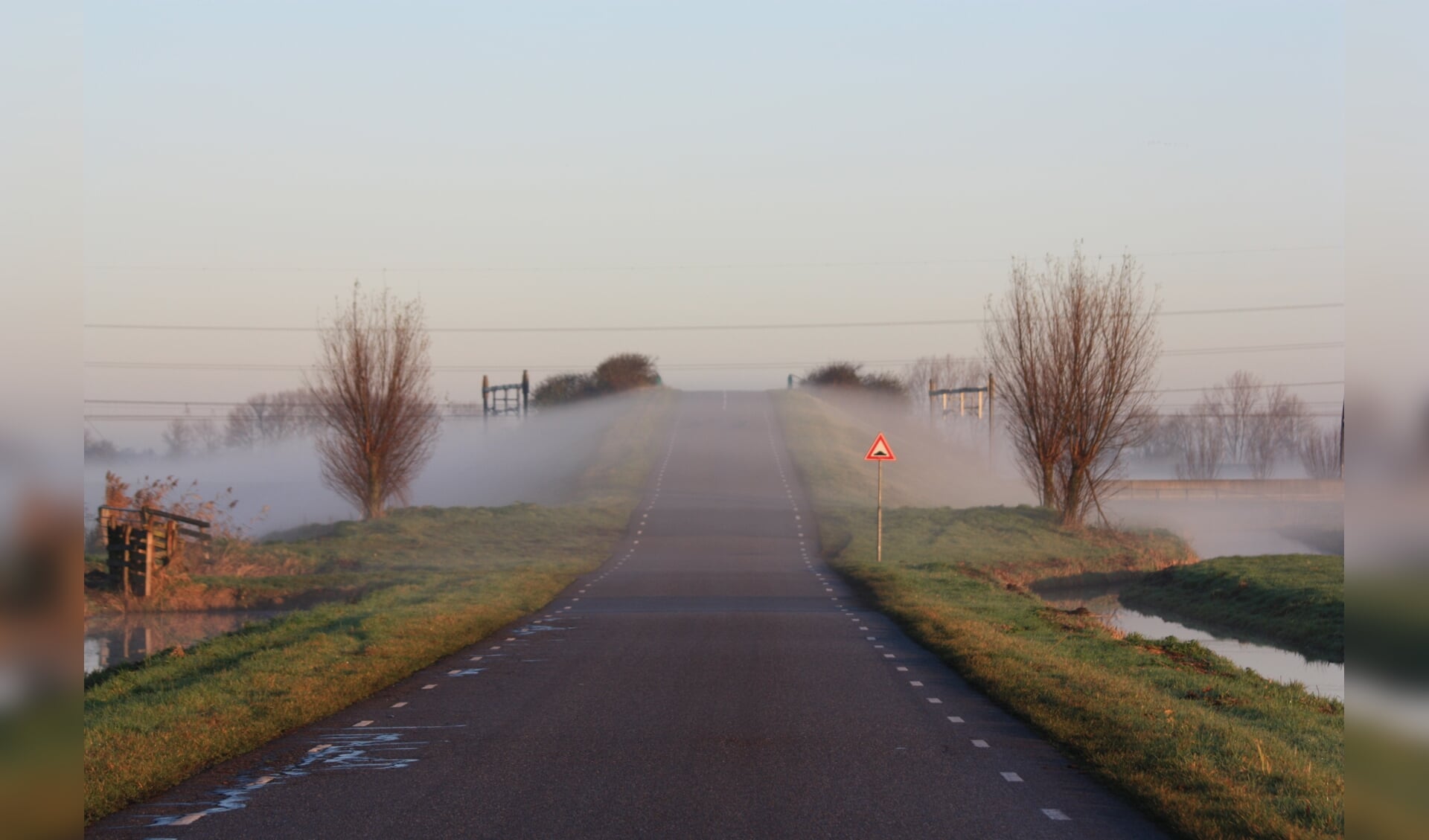 De mist steekt de weg over.