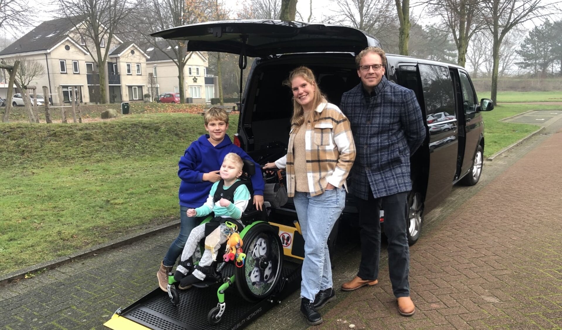 Joep de Graaf en zijn familie bij de nieuwe rolstoelbus.