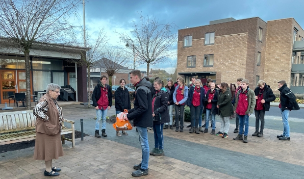 De leden bieden hun zelfgemaakte kerstattentie aan.