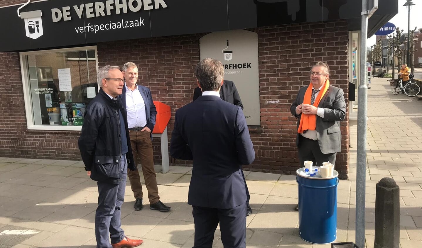 Wethouders Izaäk van Ekeren en Gerard van Deelen luisteren mee tijdens het gesprekje dat SGP-Kamerlid Chris Stoffer heeft met de eigenaar van verfspeciaalzaak De Verfhoek. 