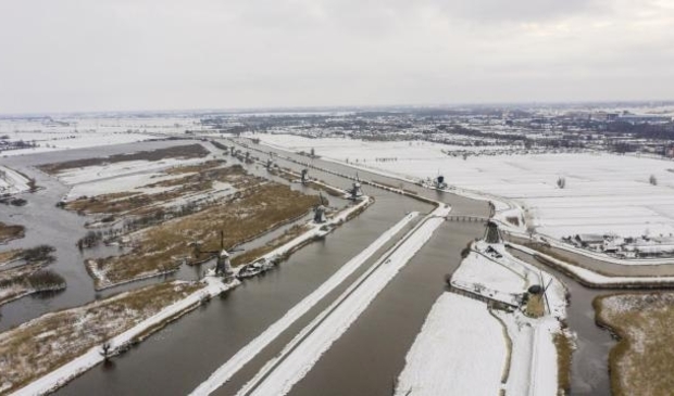 Sneeuw en ijs bij de molens van Kinderdijk in de Alblasserwaard, met links de Hoge Boezem van de Overwaard en rechts Alblasserdam.