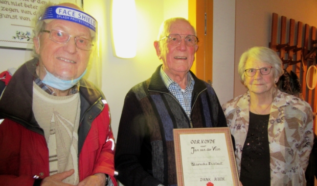 <p>Jan van der Vlies (midden) ontvangt van Piet Pols, voorzitter van de Werkgroep Dialect, een oorkonde. Inzet: Peter Bons, voorzitter HVS (links) geeft Van der Vlies een fruitmand.</p>
