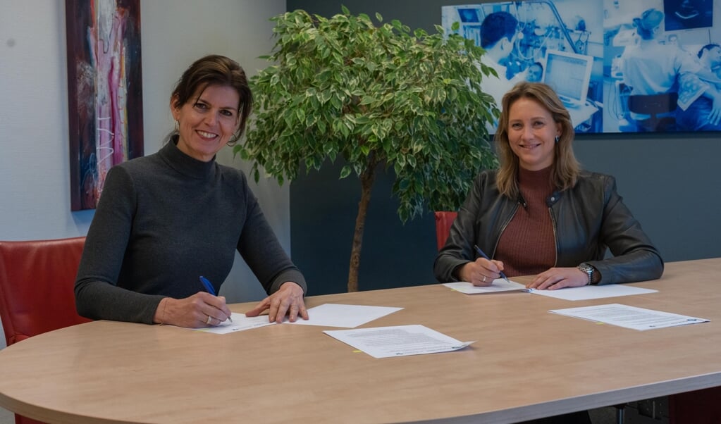Astrid Posthouwer (links), lid Raad van Bestuur Meander Medisch Centrum, en Leonie Boven lid Raad van Bestuur St Jansdal tekenen de samenwerkingsovereenkomst voor de uitbreiding van de zorg voor nierpatiënten.