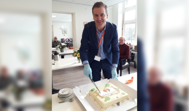 Bestuurder Cedric van der Meulen snijdt de taart aan op ontmoetingscentrum Pleinhart
