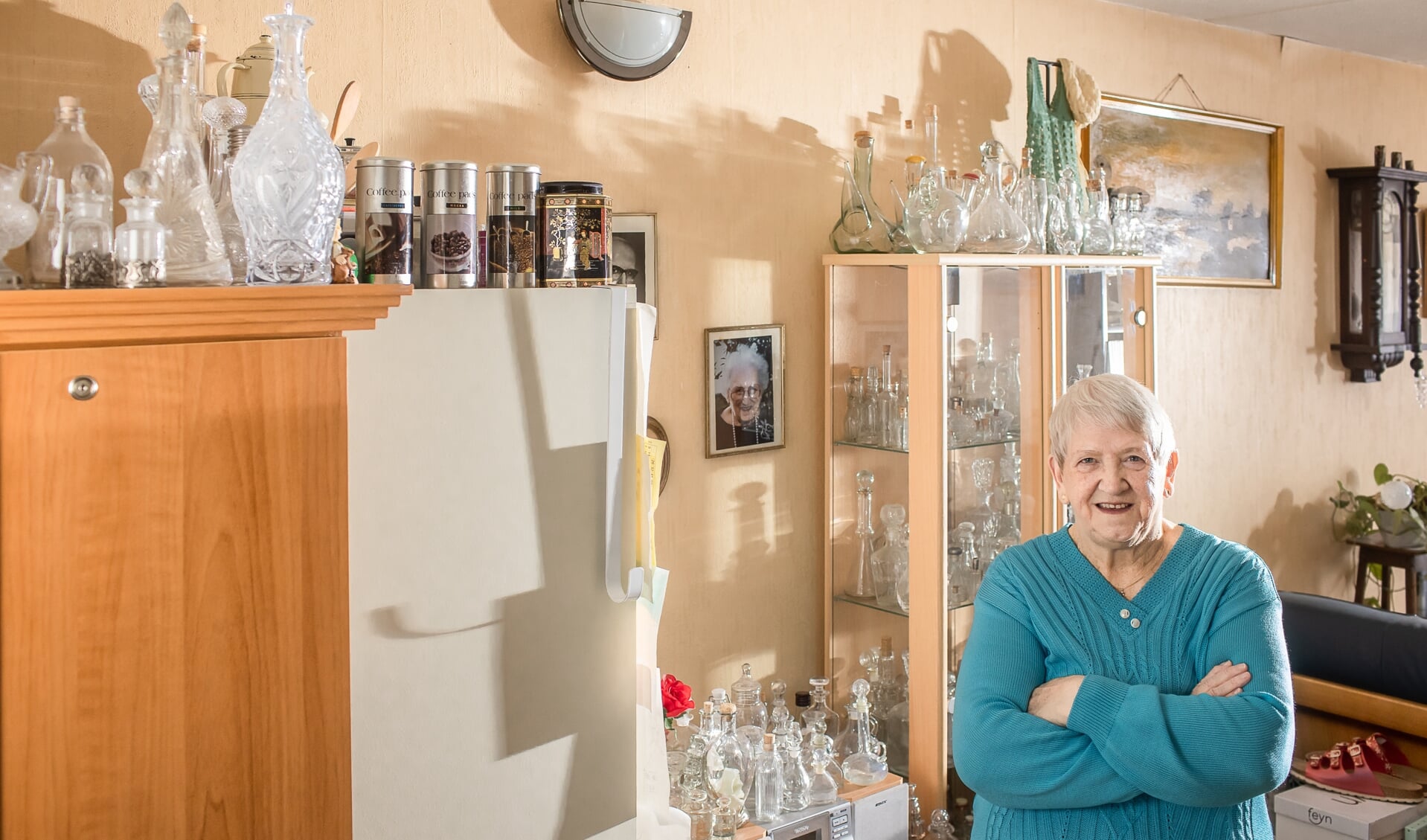 Bets ten Broek in haar woonkamer tussen de flesjes van witglas.