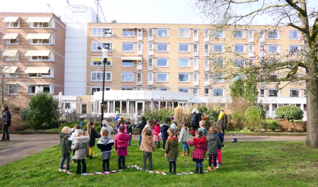 Kleuters Henri Dunantschool brengen geknutselde bloemen bij Overslydrecht.