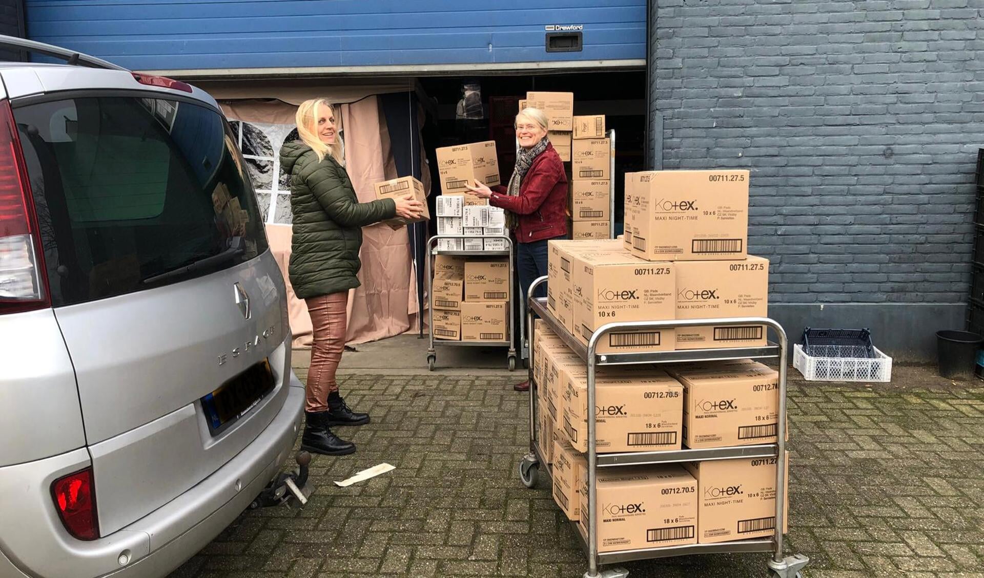 De dozen met Kotex worden overhandigd door Laura Feller aan Roos Hordijk van de Voedselbank Ede