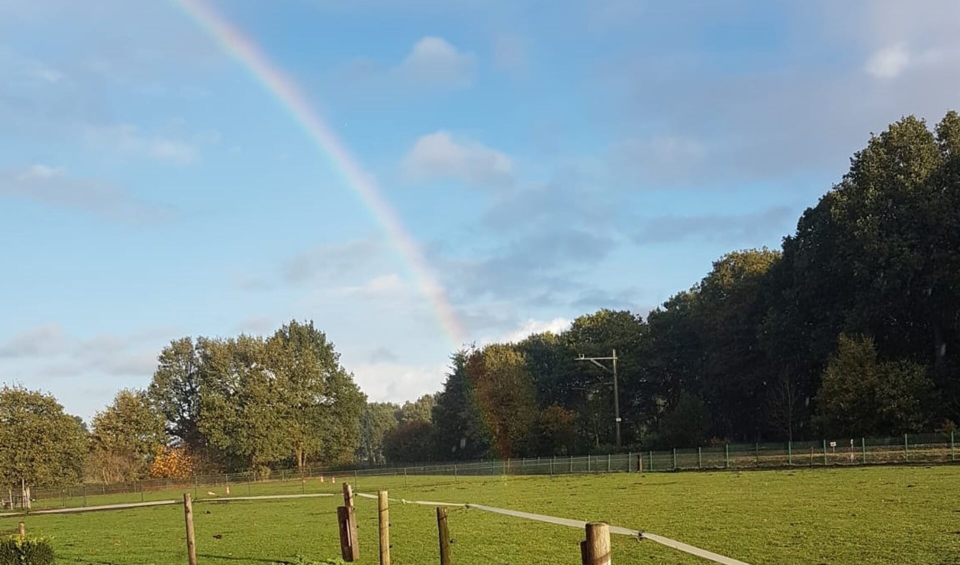 Regenboog raakt de grond nabij de Zonneoordlaan in Ede.