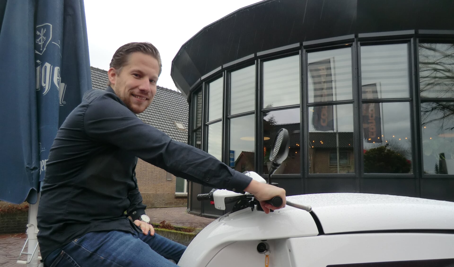 Peter zittend op een elektrische bakscooter voor de serre van Concordia Hoogland.