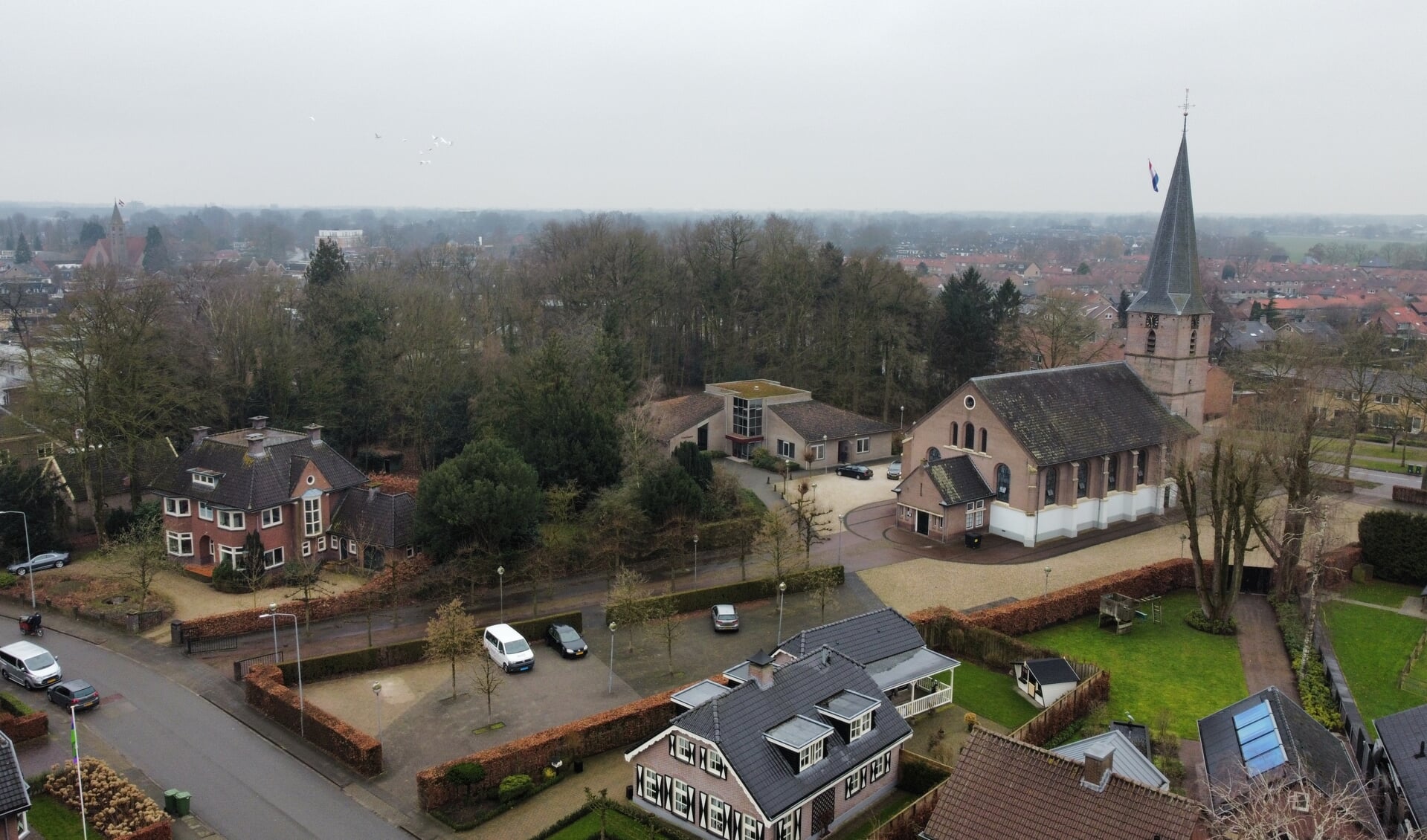 De Hervormde Dorpskerk in Voorthuizen, met links de monumentale pastorie met bijbehorende tuin.