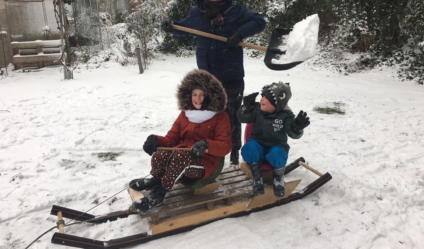 Opa John, woonachtig aan de Klomperweg in Lunteren. maakte zondag zelf in allerijl een sneeuw voor zijn kleinkinderen. Op de foto staan de kleinkinderen Liv en Milo met hun vader Koen.