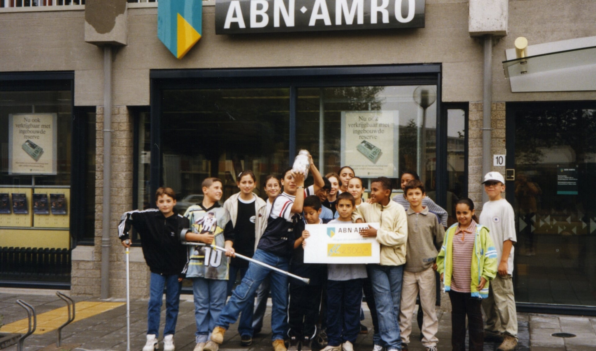 Een foto van jaren gelden, op de foto leerlingen van De Baanbreker die geld storten bij de bank voor een goede doelen actie