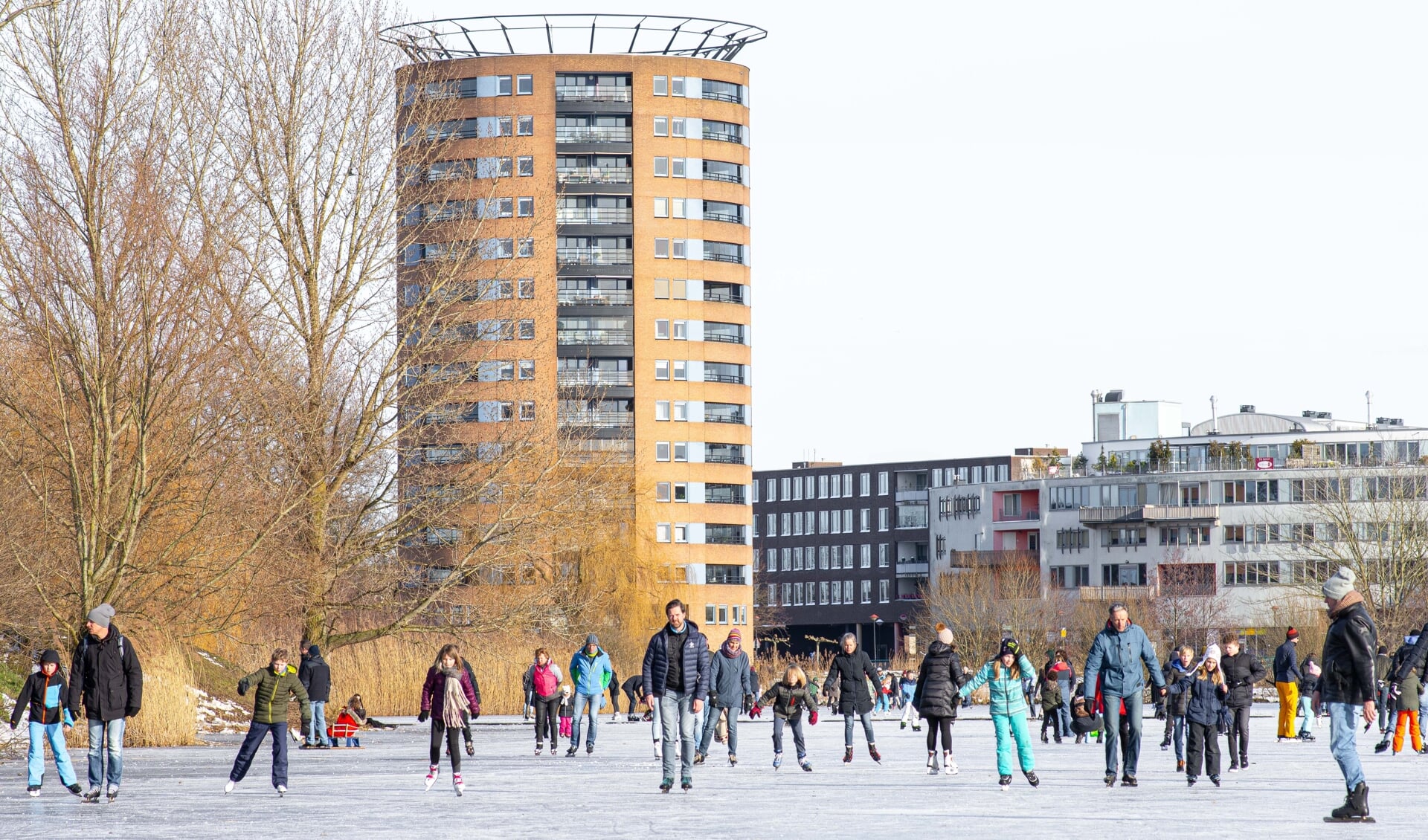 Schaatsende mensen op het ijs in Nieuwland.