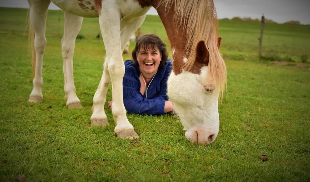 Annet Lekkerkerker met een van haar paarden die ze inzet bij therapie met kinderen.